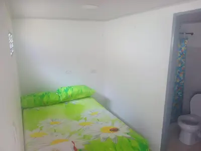 a small bedroom with a bed with flowers on it at La fonda in Santa Rosa de Cabal