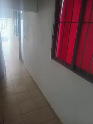 a hallway with red windows and a white wall at La fonda in Santa Rosa de Cabal