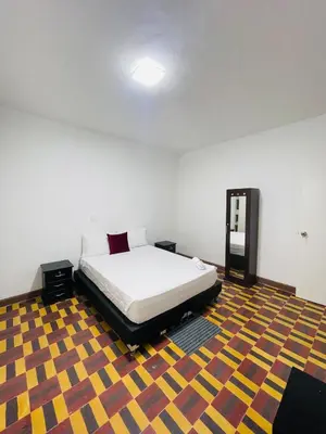 a bedroom with a bed and a colorful carpet at Grandma's House in Medellín