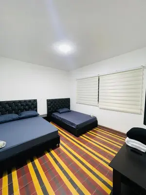 a bedroom with two beds and a table and a window at Grandma's House in Medellín