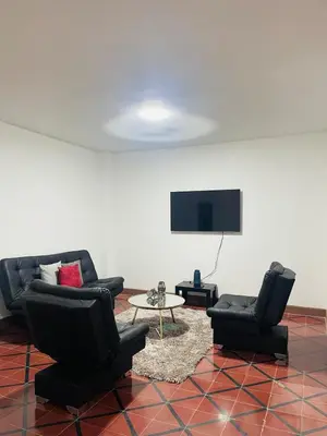 a living room with two chairs and a tv at Grandma's House in Medellín