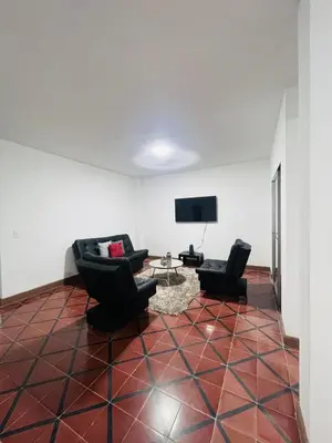 a living room with two chairs and a tv at Grandma's House in Medellín
