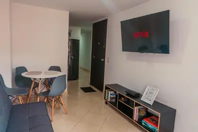 a living room with a couch and a tv on the wall at Apartamento en Sabaneta con Excelente Ubicación in Sabaneta