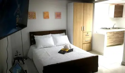 a bedroom with a bed with a book on it at Acogedor Apartaestudio in Manizales