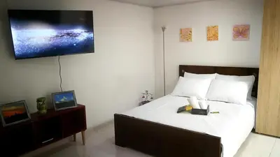 a bedroom with a bed with a tv on the wall at Acogedor Apartaestudio in Manizales