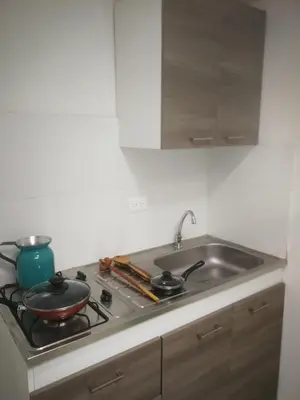 a kitchen with a stove top with a sink at Acogedor Apartaestudio in Manizales
