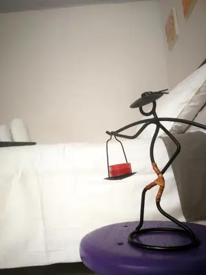 a sculpture of a woman on a purple table next to a bed at Acogedor Apartaestudio in Manizales