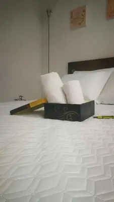 a white bed with a box of towels on it at Acogedor Apartaestudio in Manizales