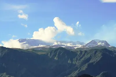 a view of a mountain range with snow capped mountains at Acogedor Apartaestudio in Manizales