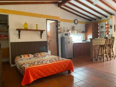 a bedroom with a bed and a kitchen with a refrigerator at Apartasol En San Jeronimo in San Jerónimo