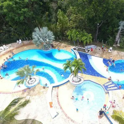 an overhead view of a large swimming pool with palm trees at Apartasol En San Jeronimo in San Jerónimo