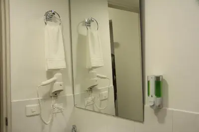 a bathroom with a mirror and towels on the wall at Almaviva Casa Hotel in Medellín