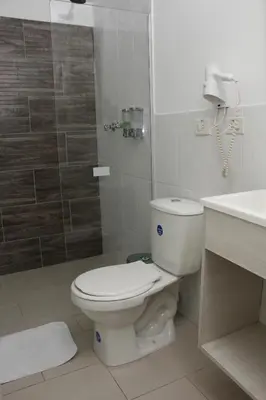 a bathroom with a toilet and a shower and a sink at Almaviva Casa Hotel in Medellín