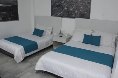 a bedroom with two beds with blue and white at Almaviva Casa Hotel in Medellín