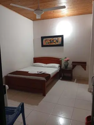 a bedroom with a bed and a table and a chair at Hotel kerana moon in Puerto Boyacá