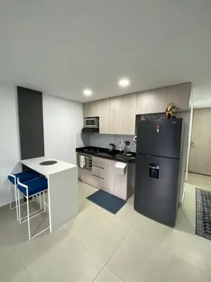 a kitchen with a black refrigerator and a table at comodo y acogedor apartamento in Sabaneta