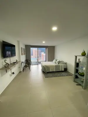 a large white room with a bed and a television at comodo y acogedor apartamento in Sabaneta