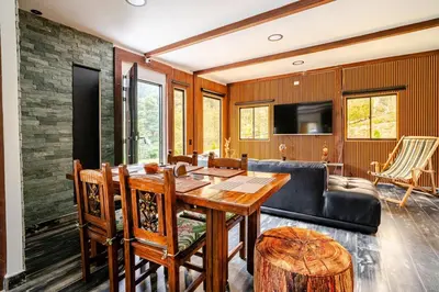a living room with a table and a couch at Nature Retreat Views, Grill, Jacuzzi & Glamping in Guarne
