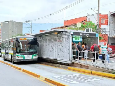 people are getting on a bus at a bus stop at Casa Bendita - Apto 102 in Medellín