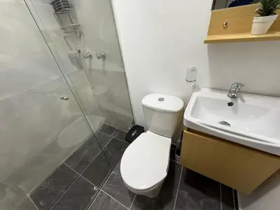 a bathroom with a toilet and a shower and a sink at Casa Bendita - Apto 102 in Medellín