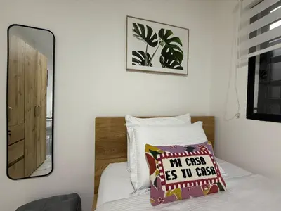 a bedroom with a bed with a mirror and a pillow at Casa Bendita - Apto 102 in Medellín