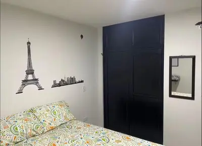 a bedroom with a bed and a black door and a mirror at Habitaciones Privadas, dentro de apartamento, cómodas y muy cercanas al Poblado in Medellín