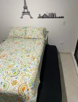 a bed with a quilt and a pillow with the eiffel tower at Habitaciones Privadas, dentro de apartamento, cómodas y muy cercanas al Poblado in Medellín