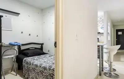 a bedroom with a bed and a table and a bathroom at Habitaciones Privadas, dentro de apartamento, cómodas y muy cercanas al Poblado in Medellín
