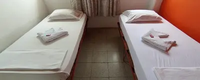 two beds in a small room with towels on them at Hotel San Judas in Santa Fe de Antioquia