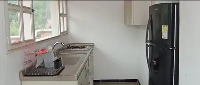 a kitchen with a sink and a black refrigerator at Hotel San Judas in Santa Fe de Antioquia