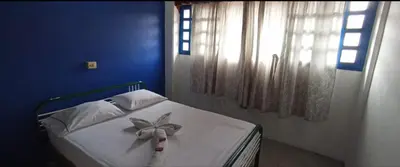 a bedroom with a white bed with a bow on it at Hotel San Judas in Santa Fe de Antioquia