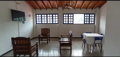 a room with chairs and a table and a tv at Hotel San Judas in Santa Fe de Antioquia