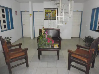 a room with two chairs and a table with flowers on it at Hotel San Judas in Santa Fe de Antioquia