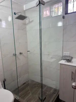 a shower with a glass door in a bathroom at Apartamento laureles estadio N 203 in Medellín