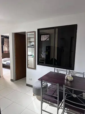 a living room with a table and a large flat screen tv at Apartamento laureles estadio N 203 in Medellín