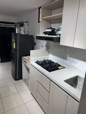 a kitchen with a stove and a refrigerator at Apartamento laureles estadio N 203 in Medellín