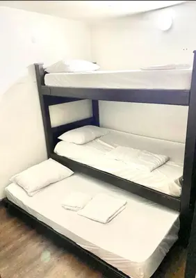 two bunk beds in a dorm room with white sheets at Apartamento laureles estadio N 203 in Medellín