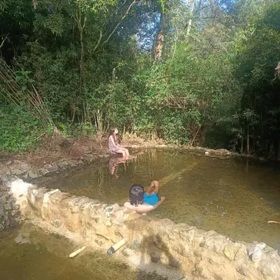 two people sitting in a pool of water at Cabañas - 5 Continentes Cerca Metrocable ARVI in Guarne