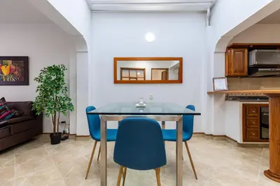 a dining room with a table and blue chairs at Stay in the most welcoming place in Medellín