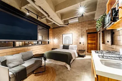 a bedroom with a bed and a couch and a tv at Otalu Suites in Medellín