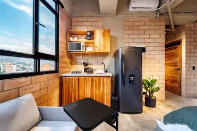 a kitchen with a stainless steel refrigerator in a room at Otalu Suites in Medellín