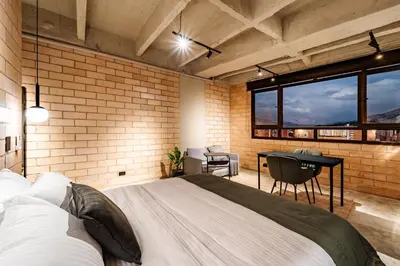 a bedroom with a large bed and a desk at Otalu Suites in Medellín