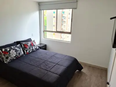 a bedroom with a black bed and a window at Selvatica 1014 in Sabaneta