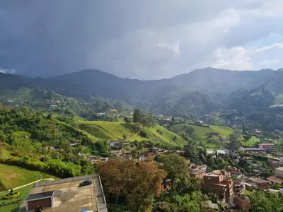 a village in a valley with mountains in the background at Selvatica 1014 in Sabaneta