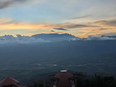 a view of a valley with clouds and a sunset at Mirador La Fortuna in San JosÃ©