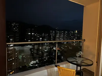a balcony with a table and a view of a city at Apartasuite Sabaneta City view parking in Sabaneta