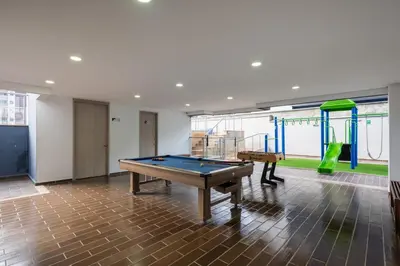 a room with a pool table and a playground at Apartasuite Sabaneta City view parking in Sabaneta