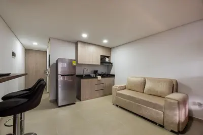 a living room with a chair and a refrigerator at Apartasuite Sabaneta City view parking in Sabaneta