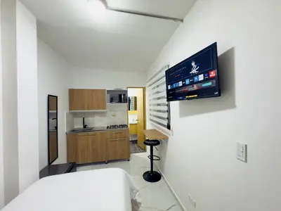 a room with a bed and a tv on a wall at Casa Bendita - Aparta estudio 104 in Medellín