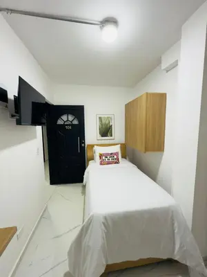 a bedroom with a white bed and a black door at Casa Bendita - Aparta estudio 104 in Medellín